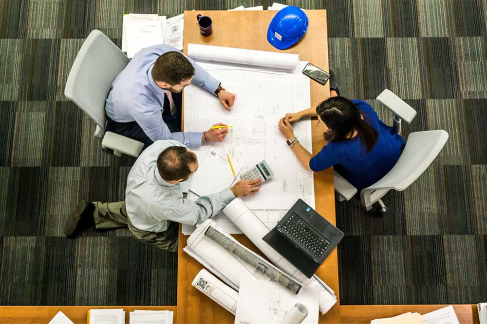 engineers working around a table discussing pricing of a construction project